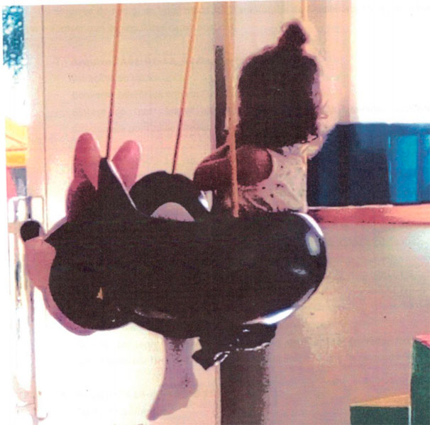 Divulgação - Imagem mostra criança amarrada por um saco de lixo, na parte de baixo do balanço da escola Divulgação - Imagem mostra criança amarrada por um saco de lixo, na parte de baixo do balanço da escola